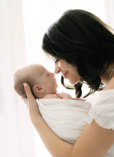 Award-winning family photography in California – mom and baby together at home couple weeks after birth, capturing love and connection in a natural, candid style.