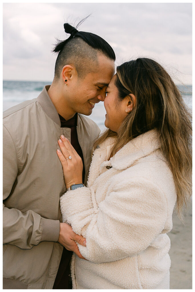 Romantic DIY beach proposal setup with red roses at Venice Beach, California.