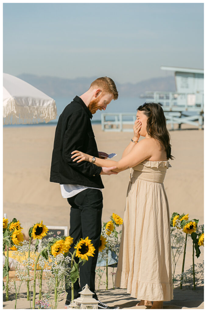 A couple embraces at their beach picnic proposal in Hermosa Beach, Los Angeles.