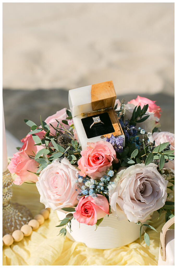 A couple embraces at their beach picnic proposal in Hermosa Beach, Los Angeles.