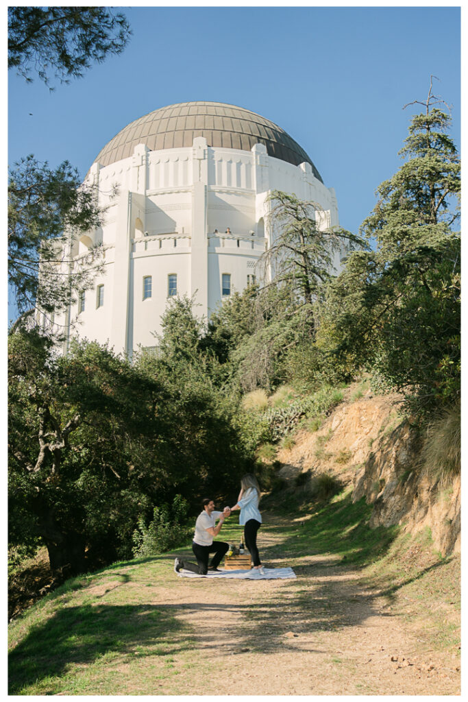 Surprise proposal setup on hiking trail at Griffith Observatory with panoramic views of Los Angeles