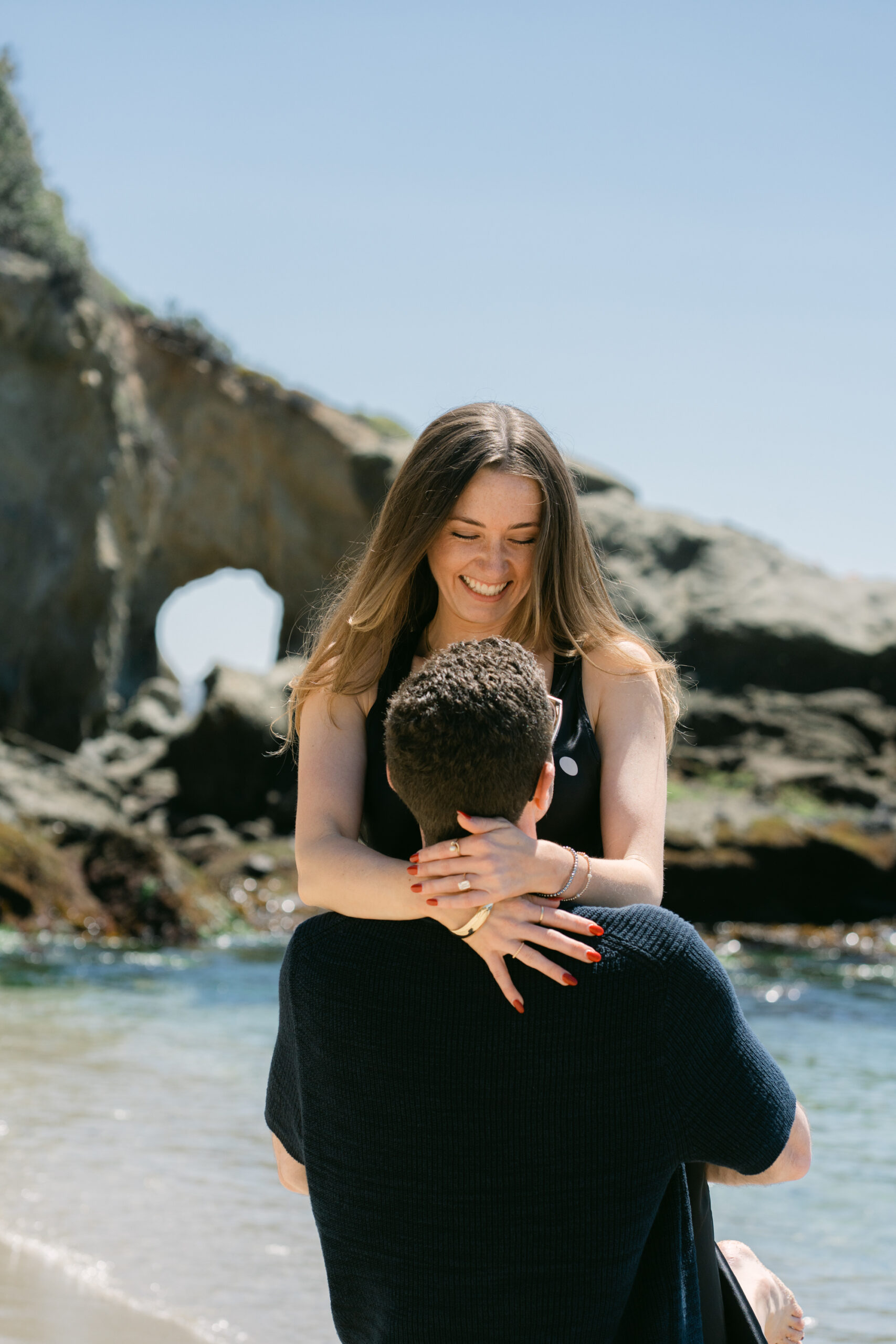 Surprise proposal at Treasure Island Beach with palm trees and ocean cliffs in Laguna Beach