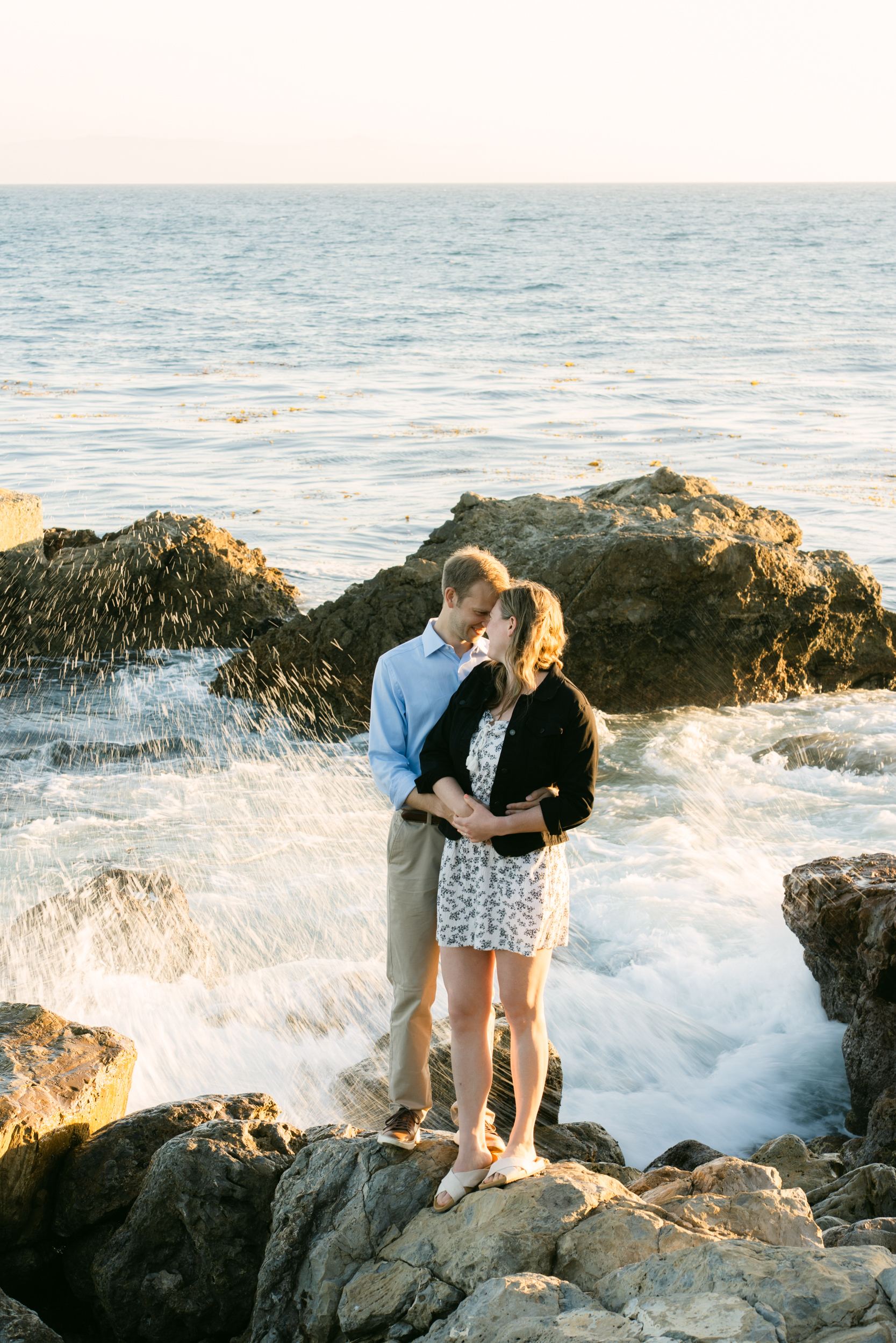 Newly engaged couple laughing and hugging after a surprise proposal at Terranea Resort