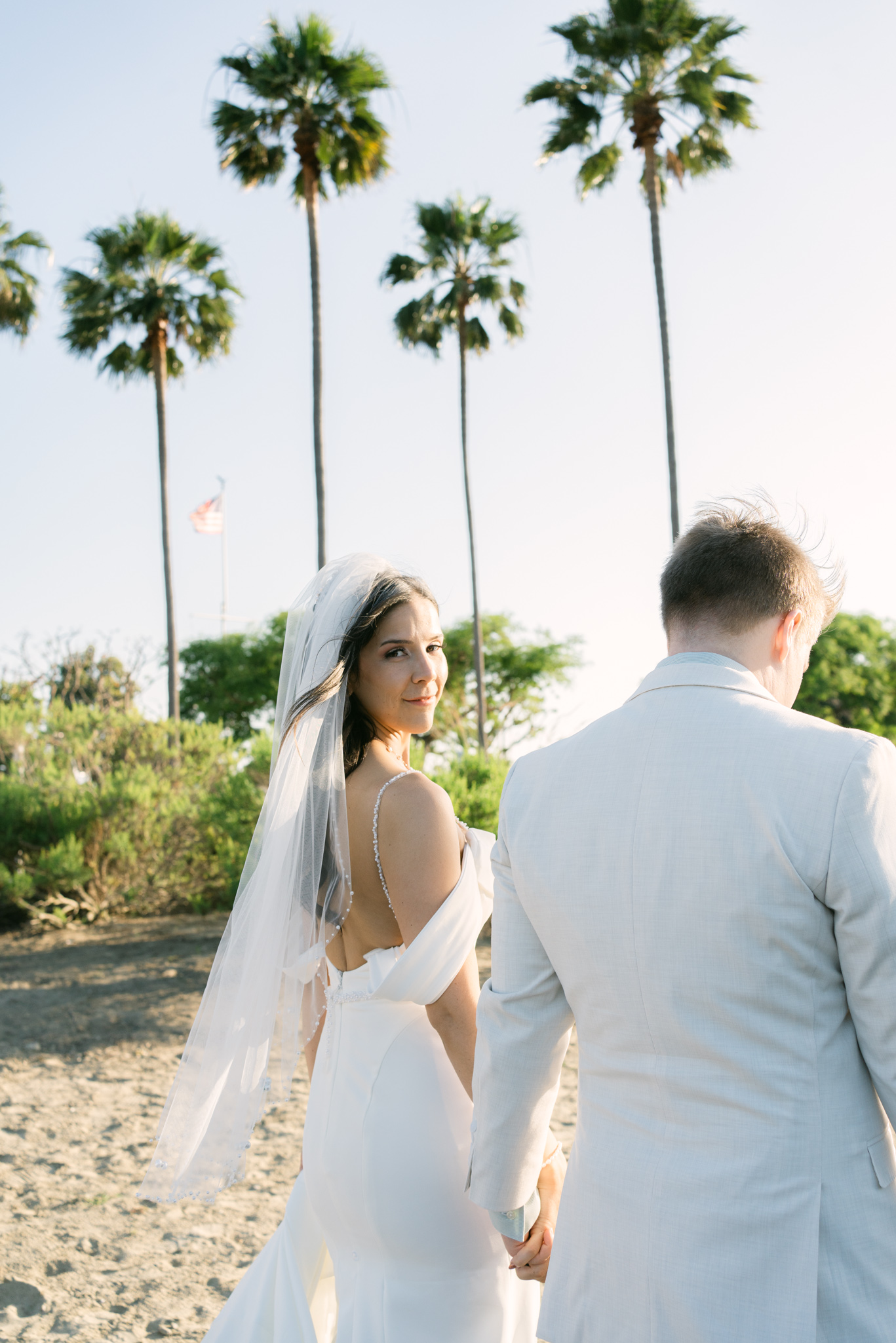 Intimate micro wedding at Lions Lighthouse in Long Beach with Sophie and Keaton standing by the water at sunset