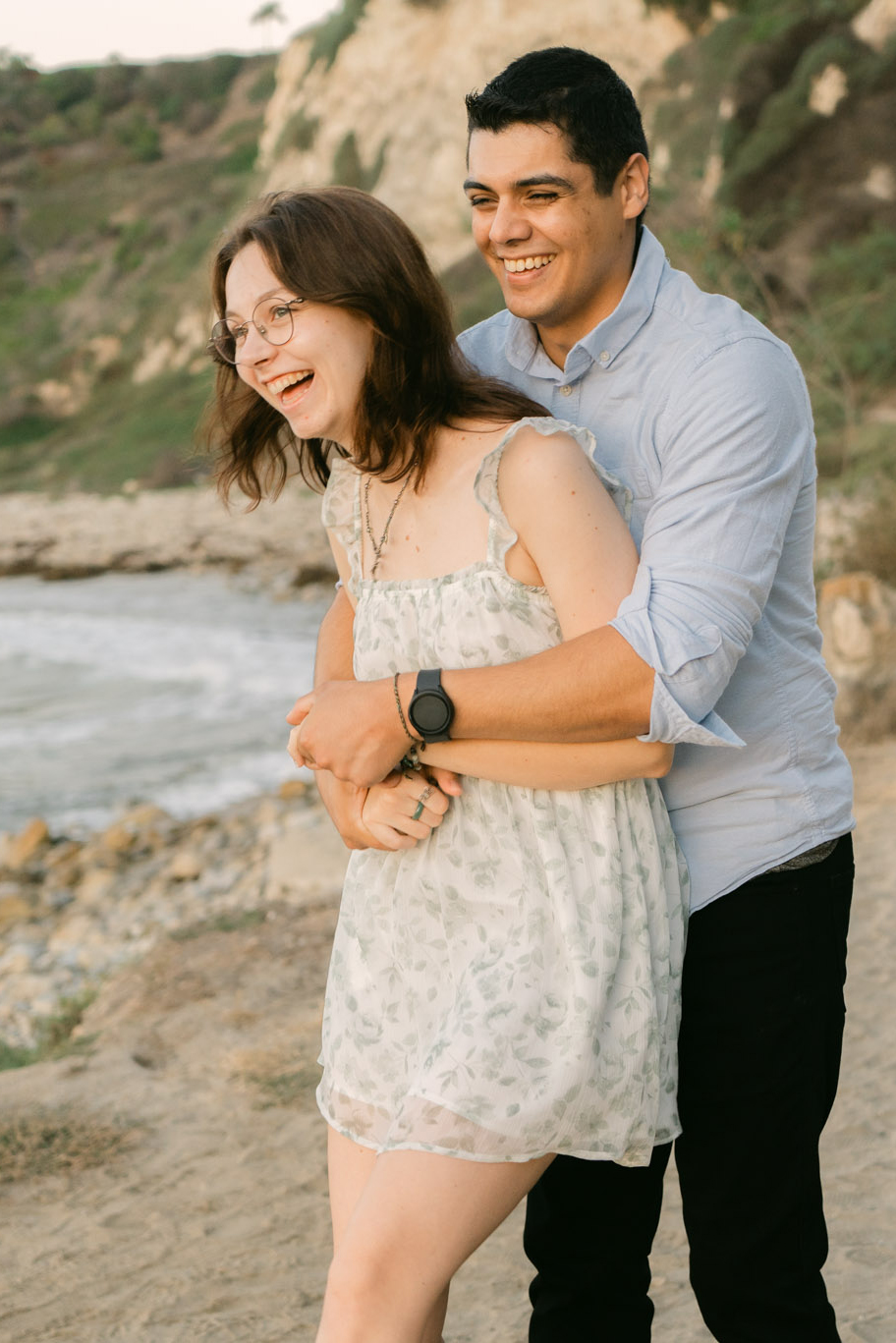 Couple embracing in golden light after saying yes during their Lunada Bay proposal in Palos Verdes.
