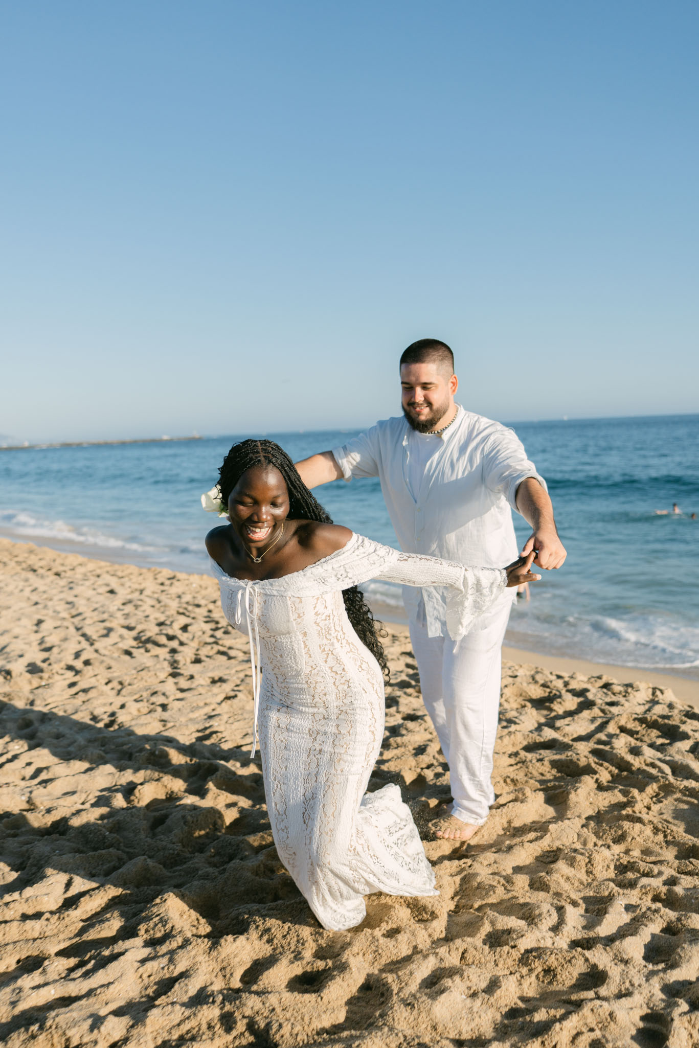 Romantic surprise proposal at Newport Beach with a picnic setup of roses, fruit, and tea captured by Southern California photographer Stephanie Ip.