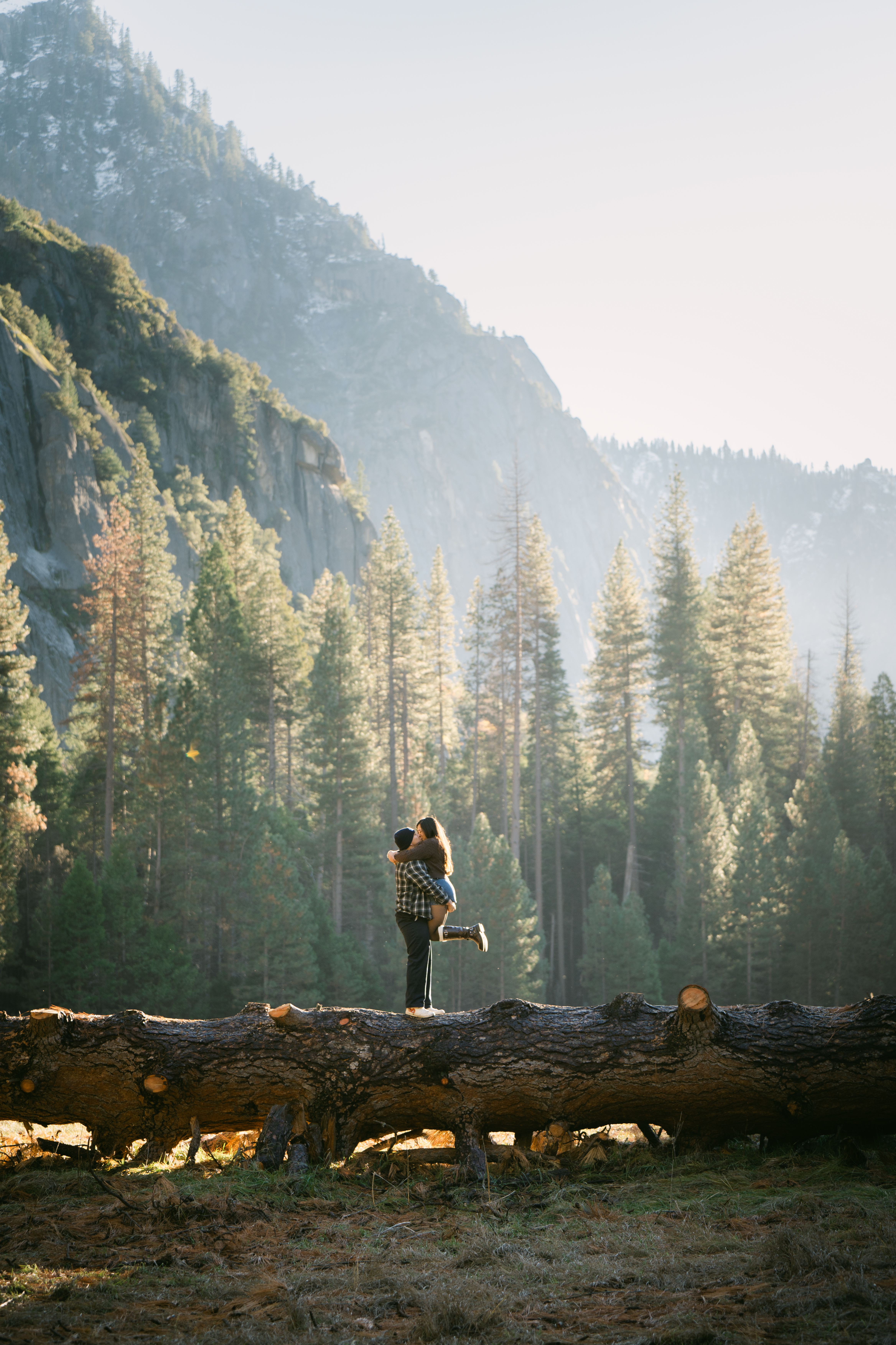 Yosemite Valley engagement photo at golden hour with couple walking in Cooks Meadow