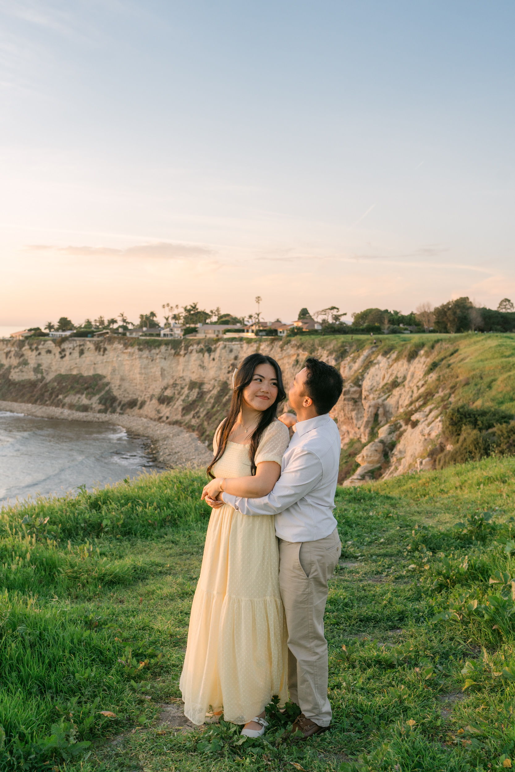 Couple standing on a cliff during a sunset surprise proposal in Palos Verdes overlooking the Pacific Ocean