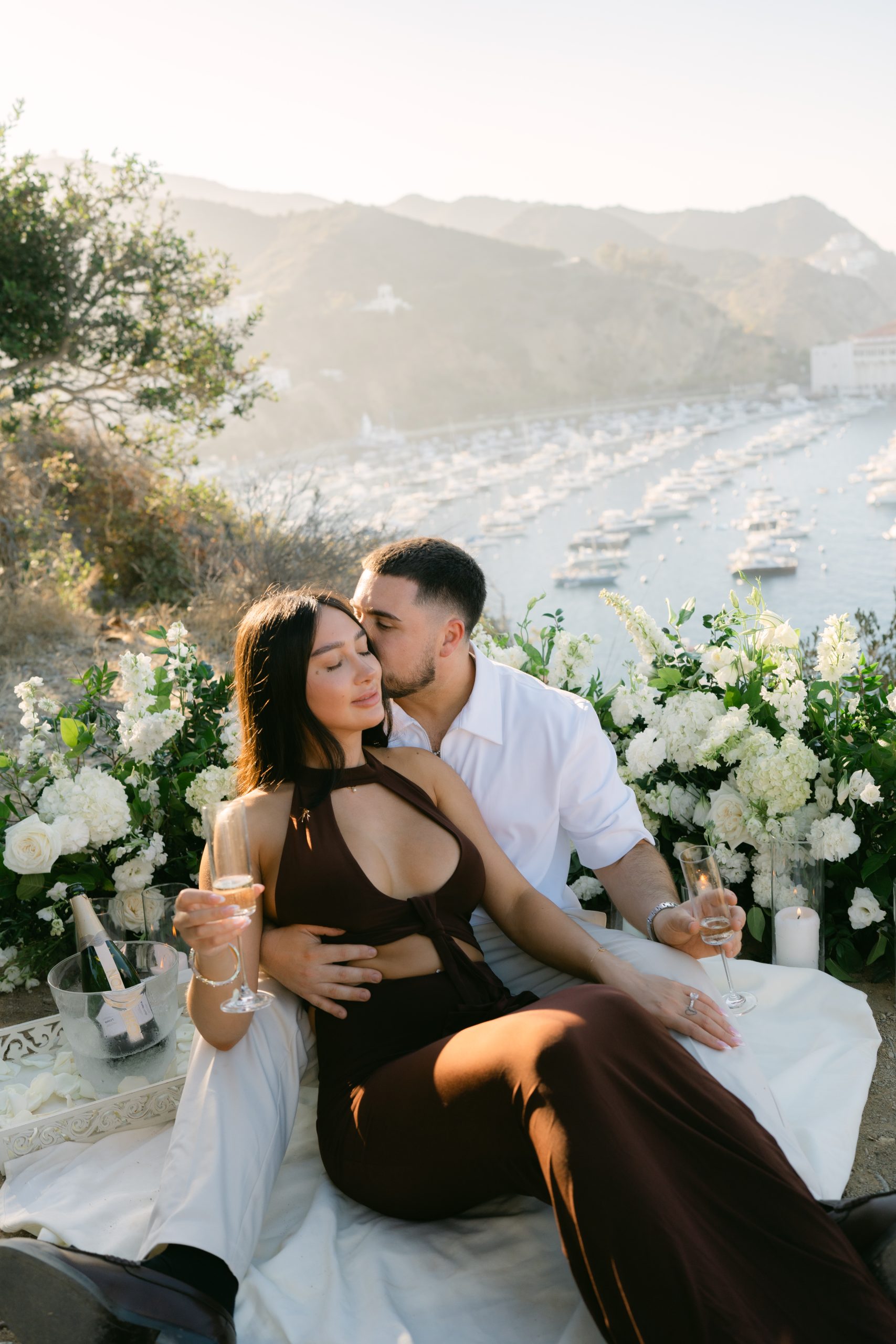 surprise proposal at Buena Vista Point Avalon Catalina Island with ocean views, floral ground arrangement candles, Southern California proposal photographer Stephanie Ip Photography